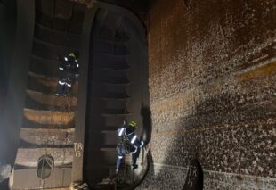 Rope access technicians inspecting internal tank structure in a confined space offshore